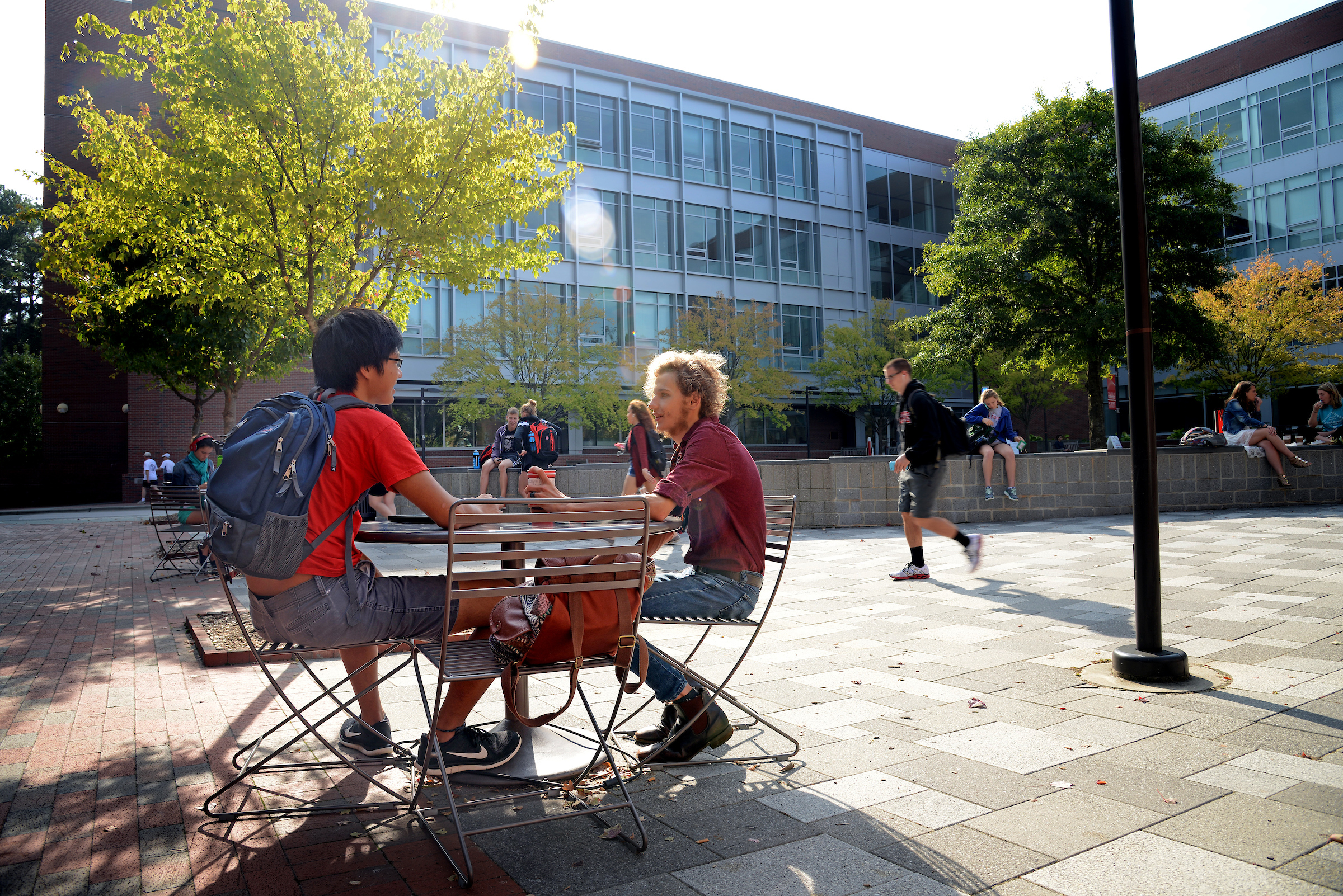 Two students speaking at table outside